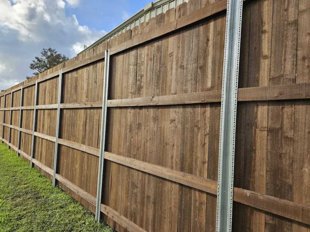 dark wooden fence with postmaster plus posts